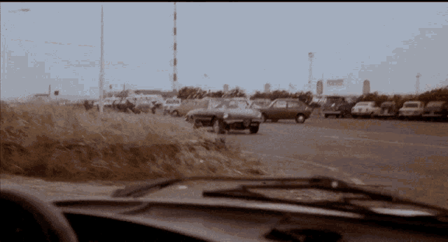 a car is parked in a parking lot with a sign in the background that says ' a ' on it