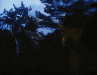 a statue of a devil with horns is standing in the dark