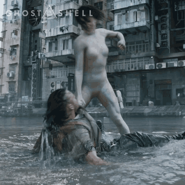 a movie poster for ghost in the shell shows a naked woman kicking a man
