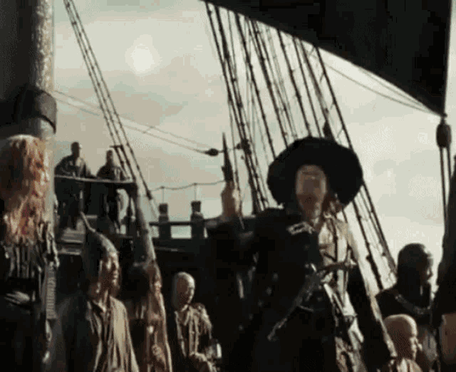a man in a black hat is standing on a ship