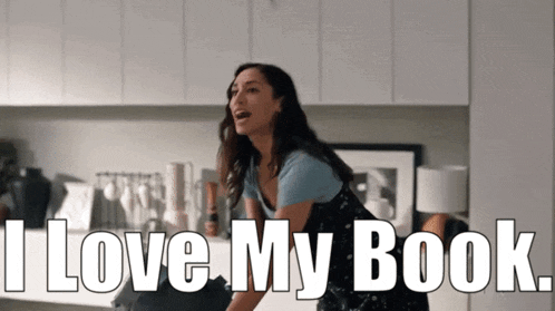 a woman says " i love my book " while standing in a kitchen