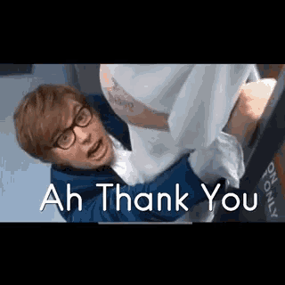 a man in glasses is holding a woman in his arms and the words `` ah thank you '' are on the screen .