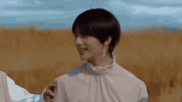 a woman in a white shirt is standing in a field with a man .