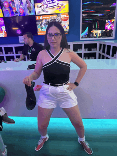 a woman standing in front of a bowling alley with a sign that says strike