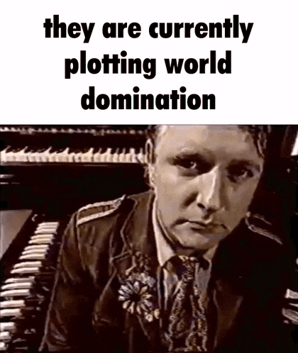 a man in a suit and tie is sitting at a piano in a meme .