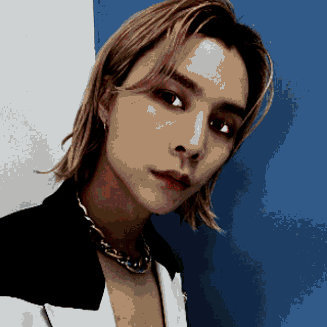 a pixelated image of a young man wearing a necklace and earrings