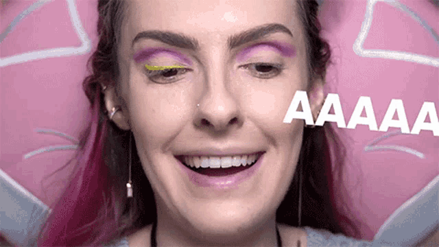 a close up of a woman 's face with a purple eyeshadow and the word aaaaa written in white