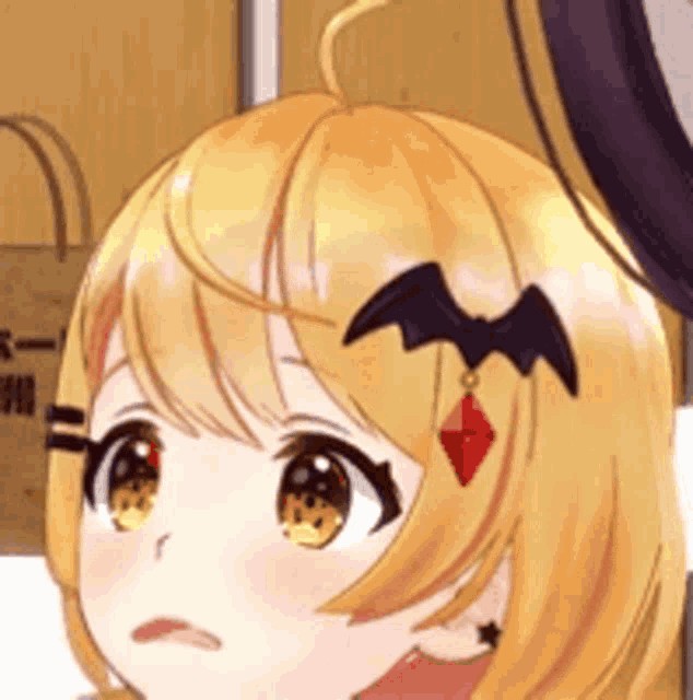 a close up of a yellow haired anime girl with a bat in her hair