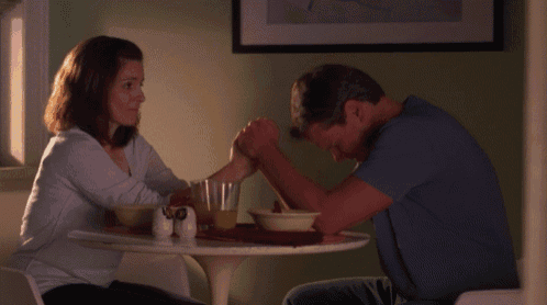 a man and a woman are sitting at a table with salt and pepper shakers on it