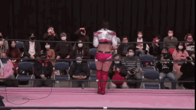 a woman in a wrestling ring with a crowd watching
