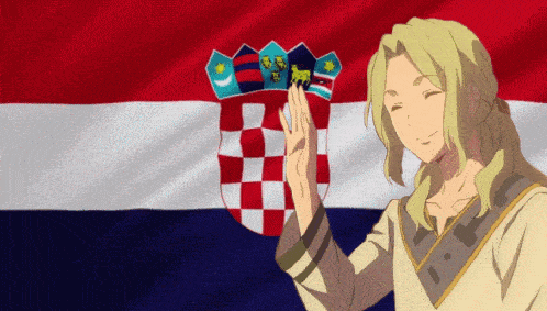 a man with blonde hair stands in front of a flag