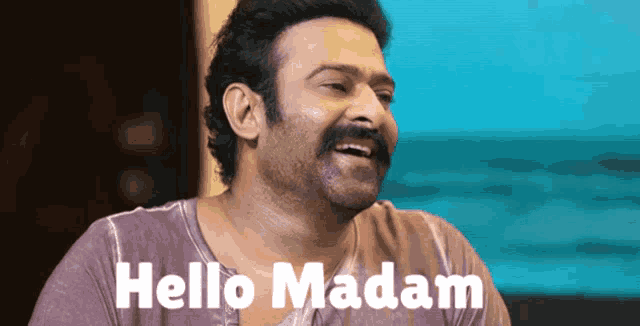 a man with a mustache says hello madam in front of a blue background