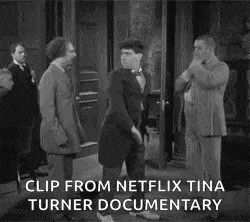 a black and white photo of two men fighting each other in a room .