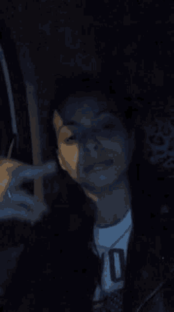 a woman is sitting in a car smoking a cigarette at night .