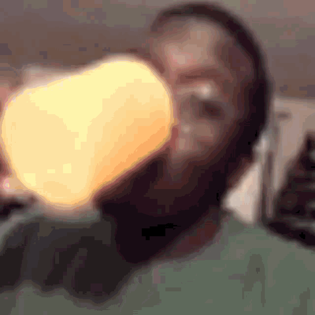 a man with a beard is drinking from a cup