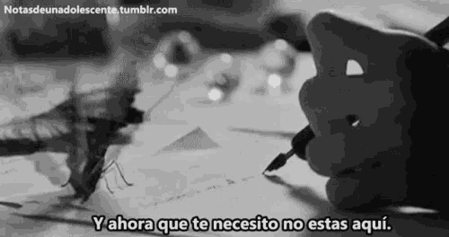 a black and white photo of a person writing on a piece of paper with the words " y ahora que te necesito no estas aqui "