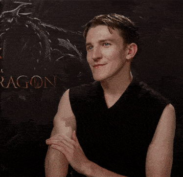 a man clapping his hands in front of a dragon sign