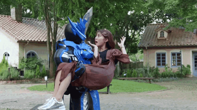 a woman in a brown dress is being carried by a robot .