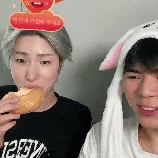 a man wearing bunny ears is eating a donut