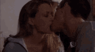 a man and a woman kissing in a dark room .