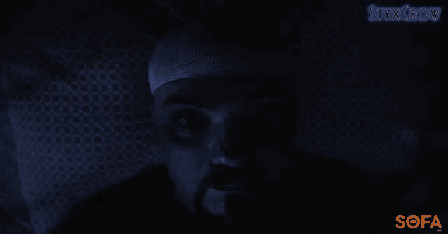 a man with a bandage on his head looks at the camera with a sofa logo in the lower right corner