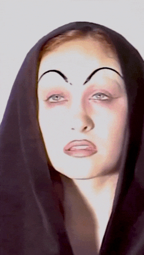 a close up of a woman 's face with a black veil covering her head