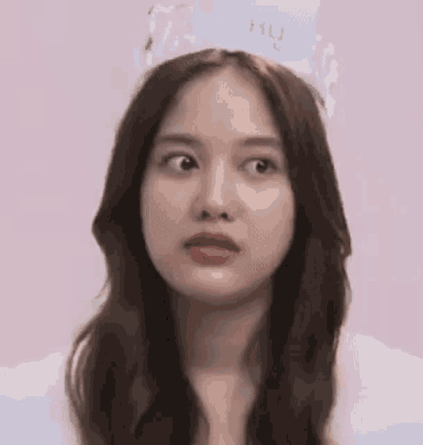 a close up of a woman wearing a crown on her head .