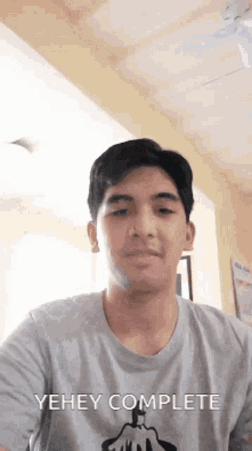 a young man wearing a t-shirt that says yehey complete on it