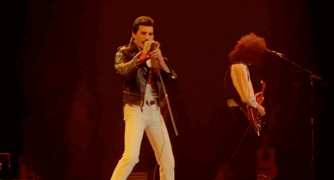 a man is singing into a microphone while another man plays a guitar
