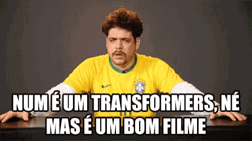 a man wearing a yellow shirt with the words num e um transformers ne mas e um bom filme