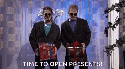 two men in suits holding presents with the words time to open presents