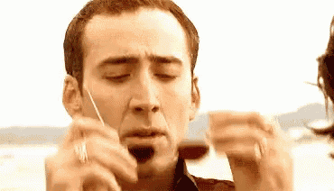 a man is holding a piece of paper in his hand and making a face .