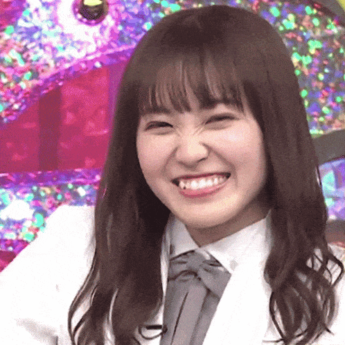 a woman in a white shirt and tie is smiling and making a funny face