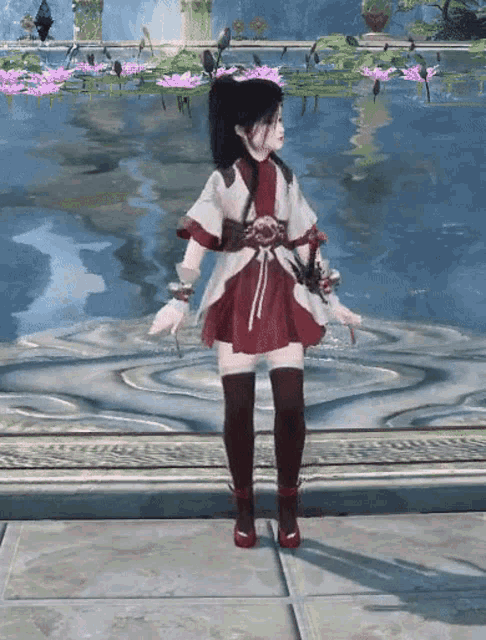 a girl in a red and white dress stands in front of a pond