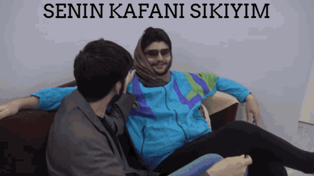 two men are sitting on a couch with the words " senin kafani sikiyom " written on the bottom