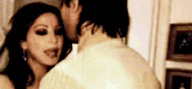 a man is kissing a woman on the cheek in a bedroom .