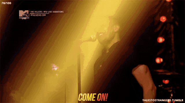 a man singing into a microphone with the words come on in red