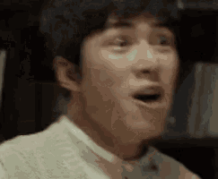 a man is making a surprised face with his mouth open .
