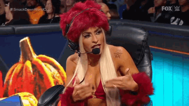 a woman is wearing a red wig and headphones while sitting in a chair .