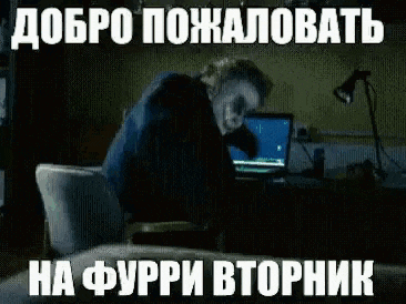 the joker is sitting at a desk with a laptop and a lamp .