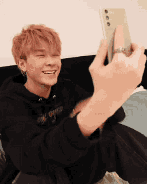 a young man is taking a selfie with a cell phone