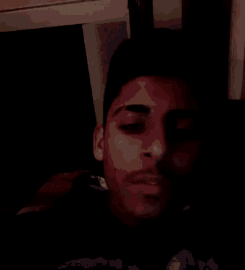 a blurry picture of a man 's face with a beard in a dark room
