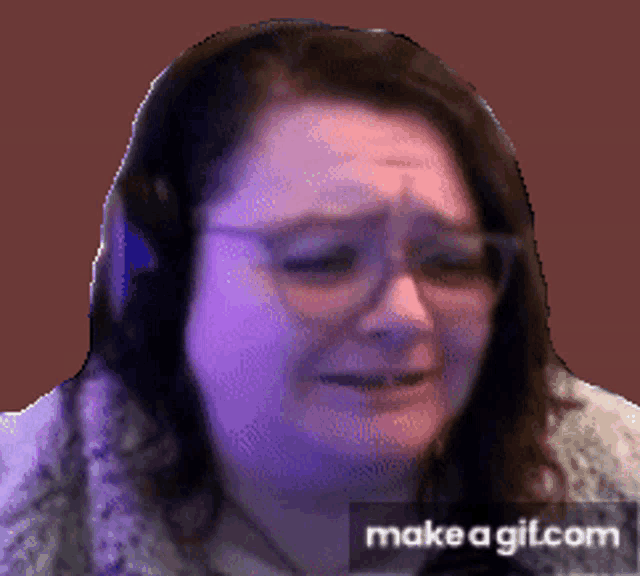 a woman wearing headphones and glasses is crying on make a gif