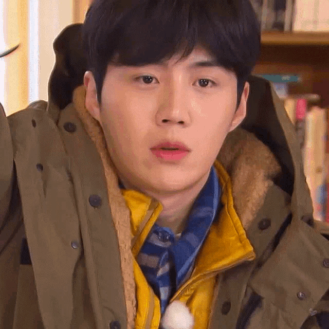 a close up of a young man wearing a jacket