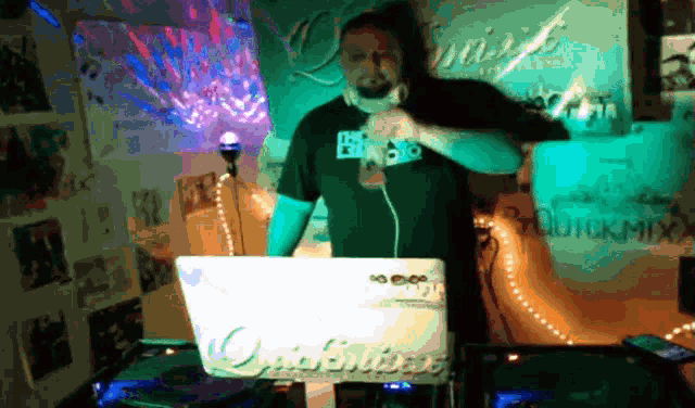 a man singing into a microphone in front of a laptop that says quickmix on it