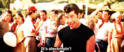 a man in a black shirt says it 's electrifyin ' in front of a crowd