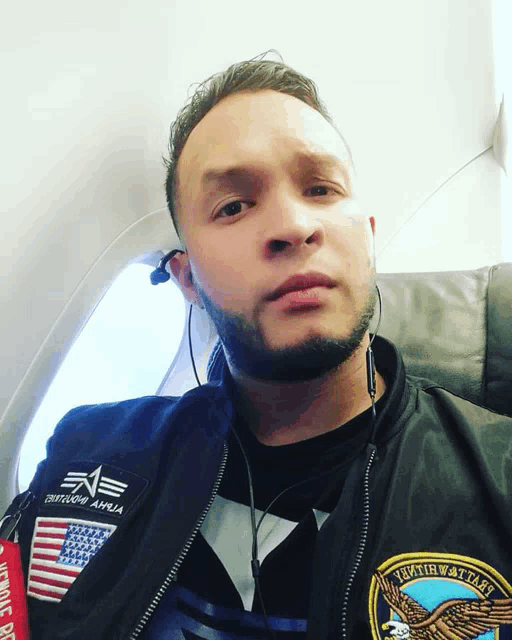 a man wearing a bomber jacket that says alpha industries
