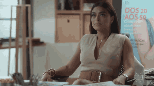 a woman sits at a desk in front of a magazine that says dos 20 aos 50