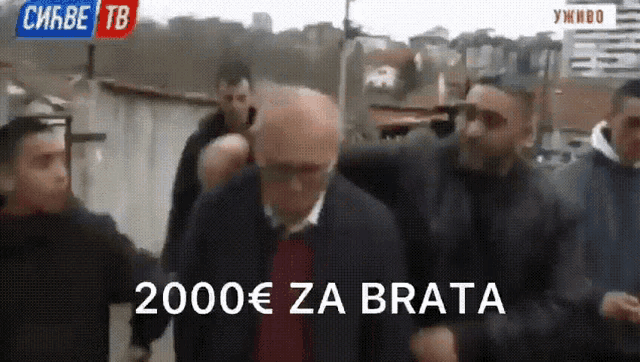 a man is being escorted by a group of men with the caption 2000 € za brata