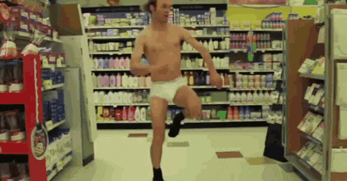 a man without a shirt is running in a store